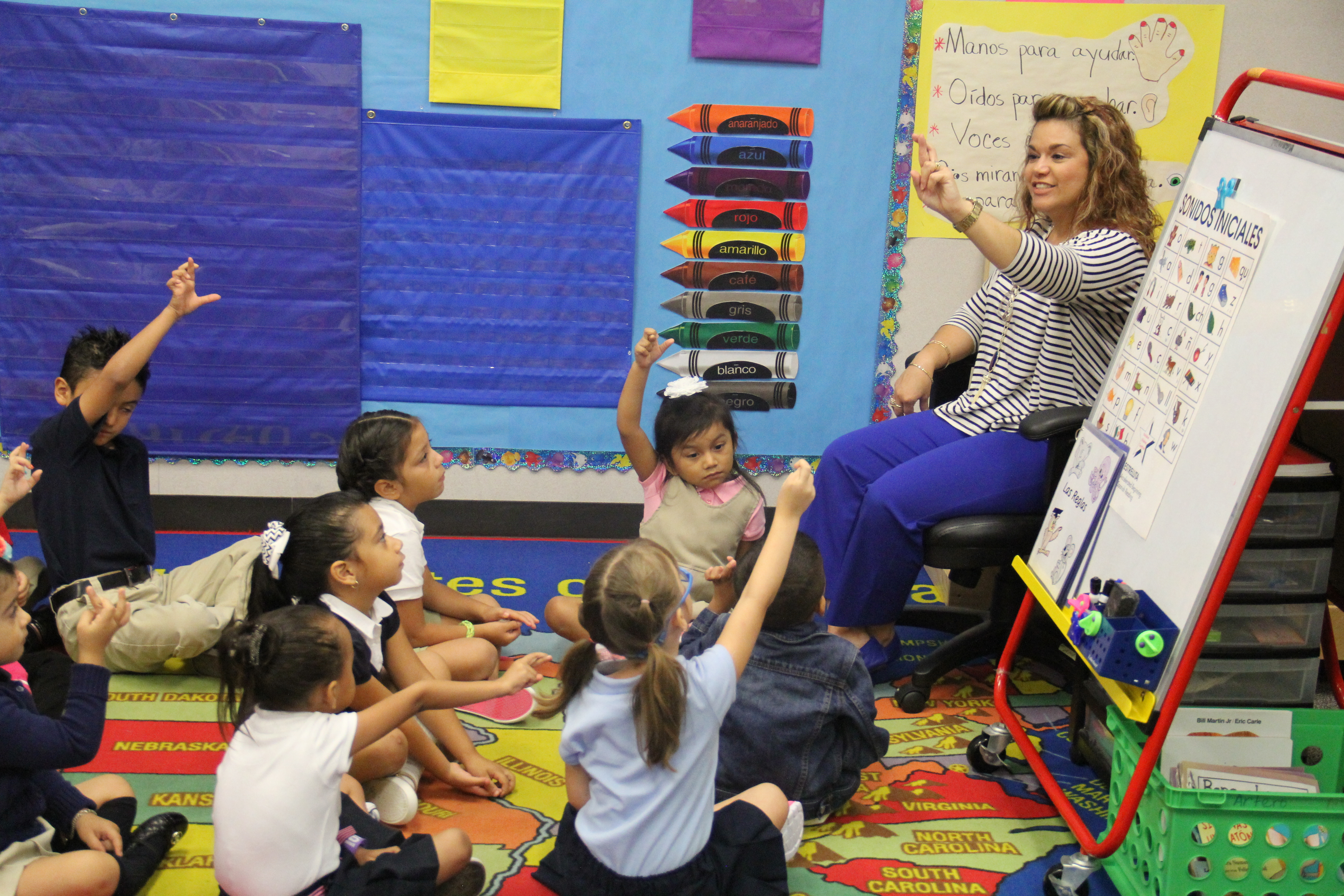 Children sitting in a circle in front of a teacher